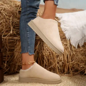 Close-up view of beige suede slip-on snow boots with plush lining and a thick sole.