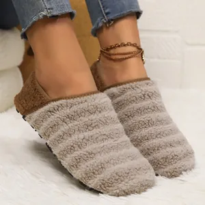 Warm winter plush flat shoes with soft non-slip sole worn on a white fuzzy rug