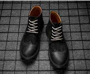 Détail de bottines richelieu noires avec texture en cuir et lacets clairs.