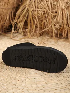 Close-up view of the durable black sole with FASHION lettering on a stylish snow boot.