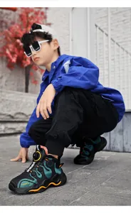 Detailed view of boy's winter plush-lined sneakers with rotary buckle on model outdoors