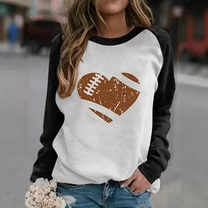 Detail view of heart football graphic on white and black raglan long sleeve shirt