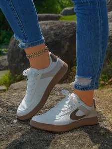 Λεπτομερής προβολή κομψών λευκών sneakers με πλατφόρμα και καφέ λαστιχένια σόλα