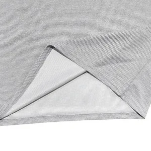 Détail macro montrant la texture du tissu en maille gaufrée grise de qualité d'une chemise