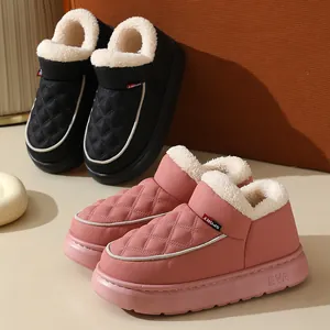 Détail de chaussons d'hiver matelassés roses et noirs avec doublure en peluche et semelles EVA.