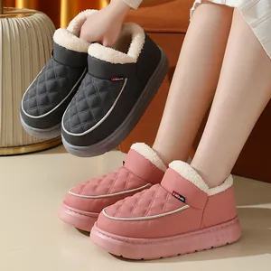 Gros plan de chaussures d'hiver roses et grises doublées de peluche avec semelles épaisses.