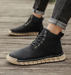 Detailed view of black hand-stitched outdoor high-top men's boots on a rustic wooden deck