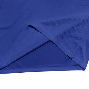 Vue macro détaillée du tissu gaufré bleu roi et de l'ourlet d'un t-shirt Henley décontracté homme