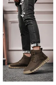 Detail view of brown hand-sewn outdoor boots for men with lace-up design and thick sole
