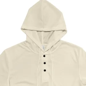 Détail d'un t-shirt Henley à capuche en maille gaufrée beige muni de trois boutons noirs