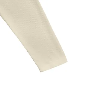 Vue détaillée de la texture en maille gaufrée sur le poignet de la manche crème