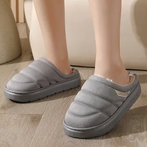 Gros plan sur des chaussons d'hiver gris rembourrés avec doublure polaire et semelle épaisse