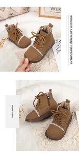 Close-up of brown suede girls' boots featuring white lace trim and side zipper closure