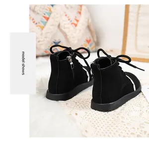 Close-up view of black girls' Martin boots with white lace trim and side zipper.