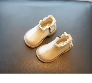 Vista detallada de los botines crema para bebé niña con elegantes volantes de encaje