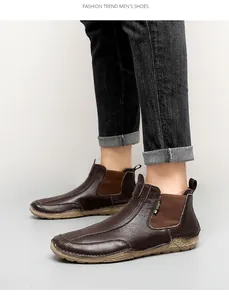Bottines en cuir marron cousues main pour hommes, portées avec un jean décontracté.