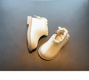Vista detallada de botas blancas de princesa para bebés con encaje y un lazo decorativo