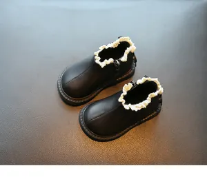Vista detallada de botines negros para niñas con un elegante borde de encaje blanco
