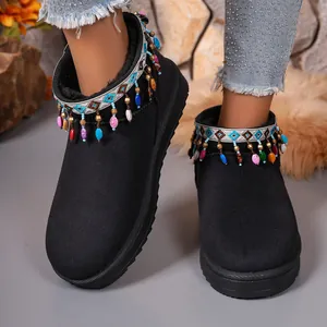 Detail view of black snow boots featuring vibrant ethnic embroidery and beaded tassels.