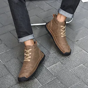 Close-up of men's brown high-top leather boots with detailed handmade stitching.