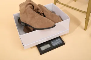 Botas altas occidentales de ante marrón en una báscula electrónica para medir el peso