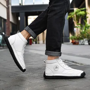 Detail view of white hand-stitched high-top Martin boots on street pavement.