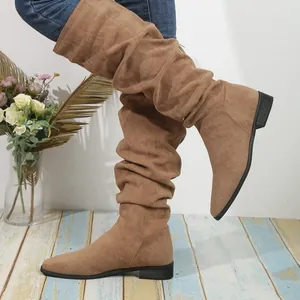 Detalle de botas vintage de ante marrón con punta afilada y tacón plano elegante