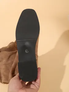 Vista detallada de la suela de botas western de ante marrón con marca de talla 37