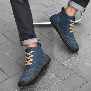 Detail view of blue men's high-top leather boots featuring decorative manual stitching