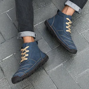 Close-up of blue handmade stitched men's high-top leather boots on grey tiles