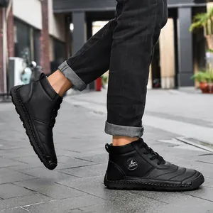 Close-up of men's black high-top leather boots with hand-stitched detailing on street