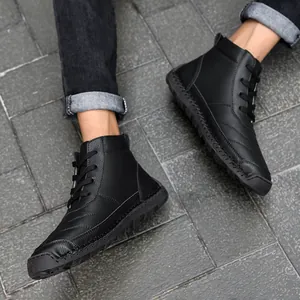Detailed view of black men's high-top leather boots featuring handmade stitching design