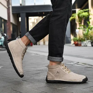 Close-up of men's beige high-top Martens boots with contrast stitching detail
