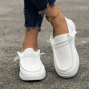 Close-up of white ribbed loafers featuring casual slip-on design and lightweight flat sole