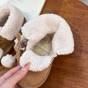 Toddler girls' brown suede snow boots featuring warm white plush faux fur lining and pom-pom