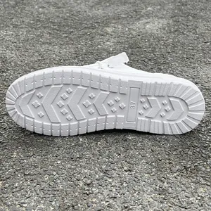 Detailed macro view of the textured non-slip outsole on white women's casual loafer