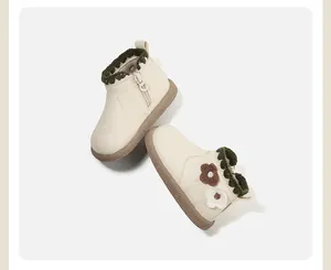Detailansicht der cremeweißen Kleinkindstiefel mit Häkelbesatz und Blumenakzenten.