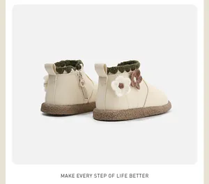 Rückansicht cremefarbener Kleinkindstiefel mit dekorativen Strickblumen und grünem Rand