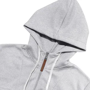 Gedetailleerde weergave van een grijze zware fleece hoodie met rits en witte koorden