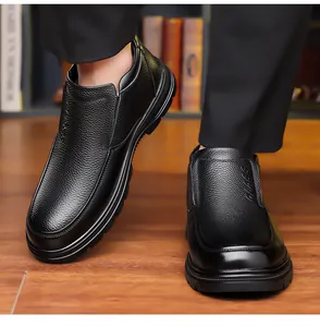 Primer plano de zapatos de invierno de cuero negro para hombre en suelo de madera