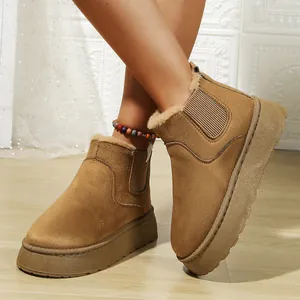 Detail view of stylish tan suede platform snow boots with warm faux fur lining on feet