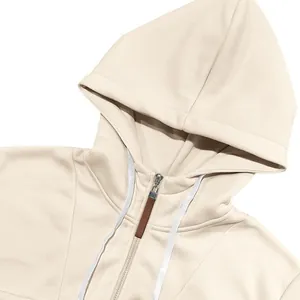 Detailopname van een zware fleece hoodie in crème met rits en trekkoord in de kap