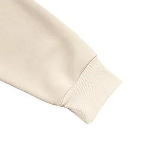 Nahaufnahme des cremefarbenen gerippten Kapuzenpullover-Bündchens und des schweren Vliesstoffs.