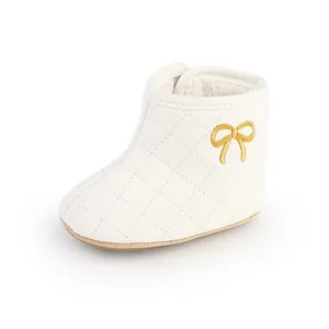 Detailansicht weißer gesteppter Babystiefel mit weichem Fleecefutter und goldener Schleife