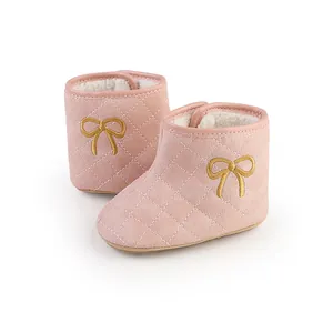 Detailansicht der rosa gesteppten Babystiefel mit goldener Schleife und Fleece-Futter.