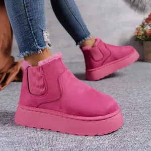 Close-up of bright pink platform snow boots with warm faux fur lining and thick soles