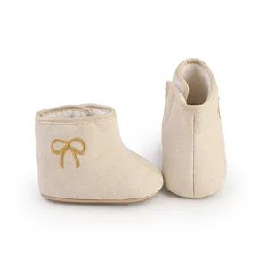 Warme beige Baby-Lauflernschuhe mit Steppmuster und eleganter goldener Schleifenstickerei
