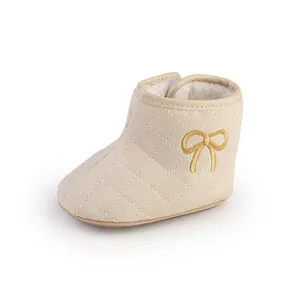 Detailansicht beige gesteppte Babyschuhe mit bestickter Schleife und Fleecefutter