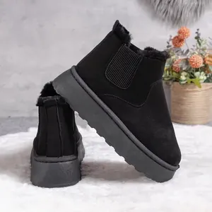 Close-up of black platform snow boots with warm faux fur lining and suede finish