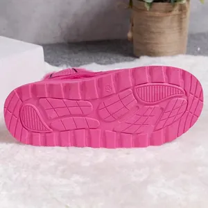 Detailed view of the vibrant pink anti-slip rubber sole of a thick winter snow boot